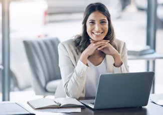 Mulher sorrindo na frente de um laptop